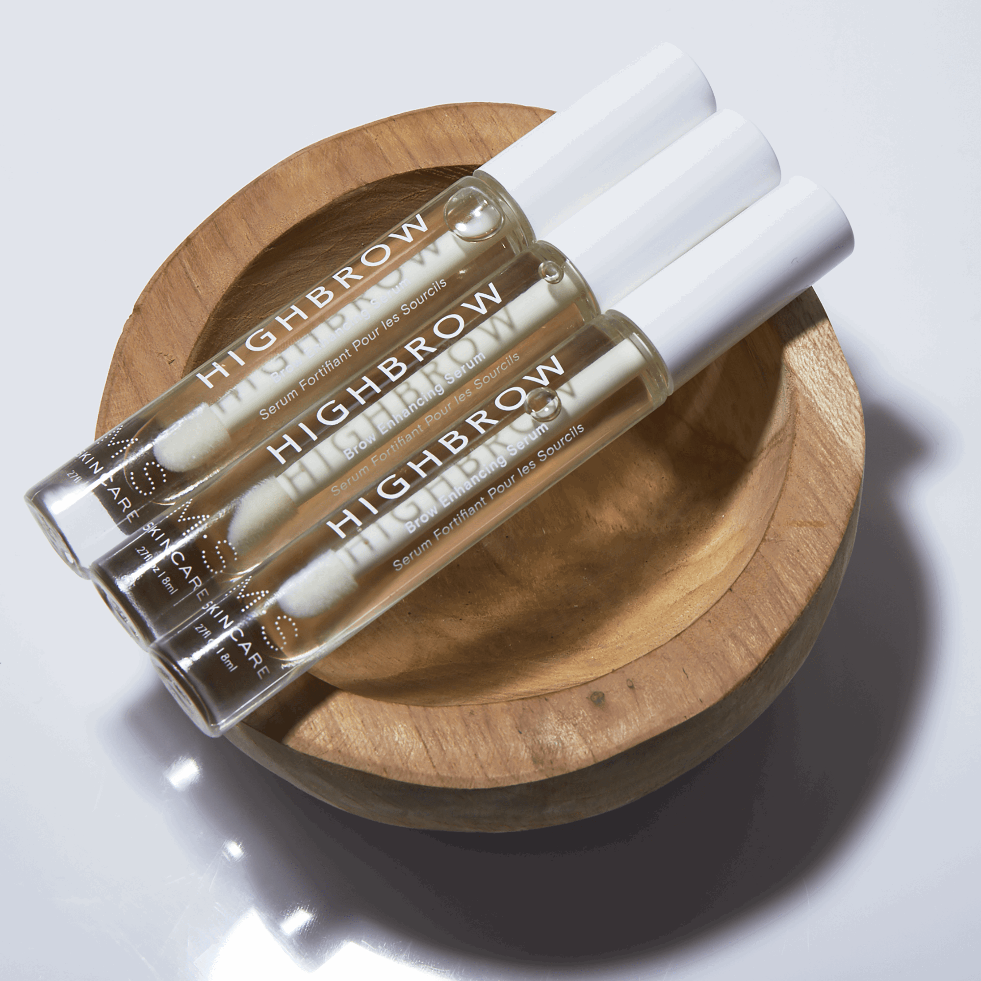 HIGHBROW by M.S. Skincare brow serum in glass bottle with white applicator wand