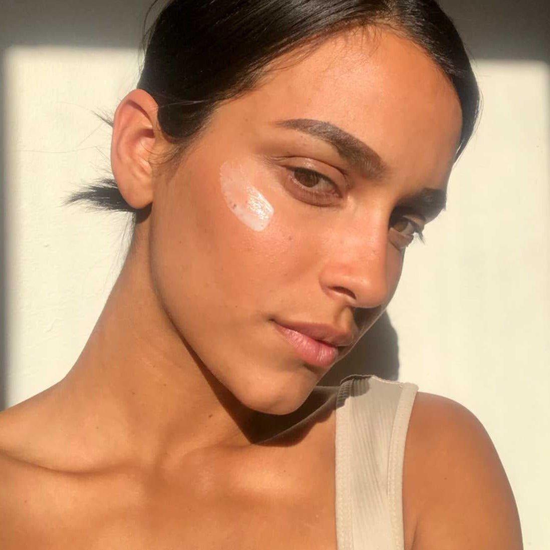 A dab of M.S Skincare ROSEWATER CREAM Radiance Enhancing Moisturizer on an olive skinned model with dark hair and eyes.